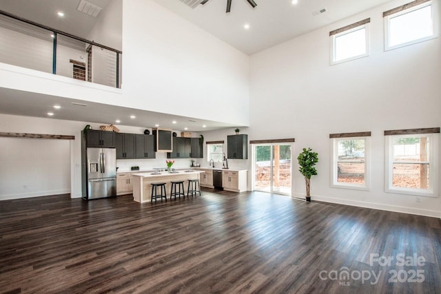 living room featuring dark wood-type flooring and a towering ceiling