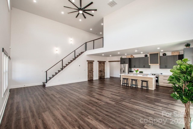 unfurnished living room featuring dark wood-type flooring and a high ceiling