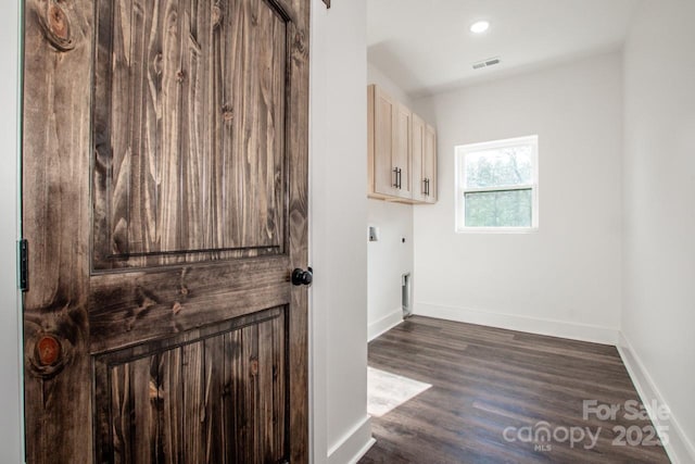 laundry area with dark hardwood / wood-style flooring, electric dryer hookup, and cabinets