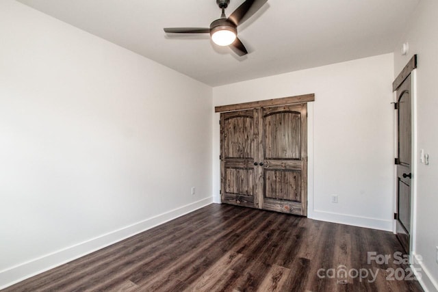 unfurnished bedroom with ceiling fan and dark hardwood / wood-style floors