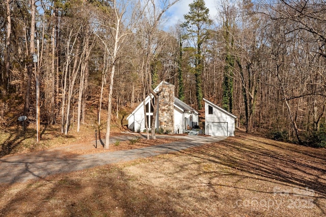 view of home's exterior with a garage and an outdoor structure