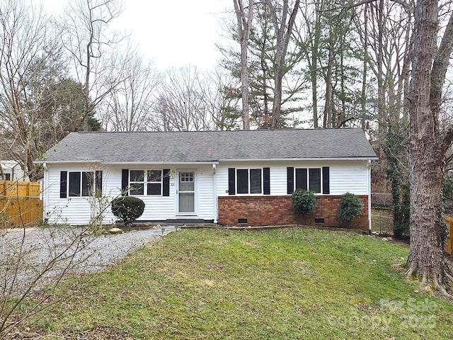 ranch-style home featuring brick siding, fence, roof with shingles, crawl space, and a front yard