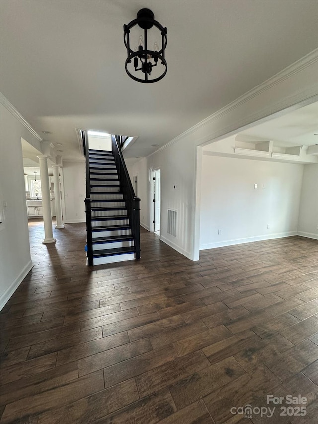 interior space featuring wood-type flooring, crown molding, a chandelier, and ornate columns