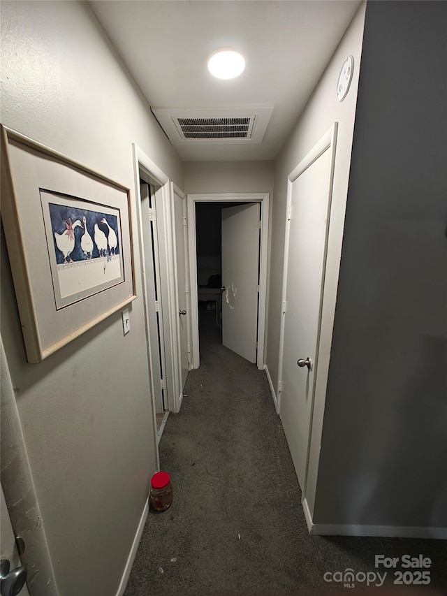 hall featuring dark colored carpet