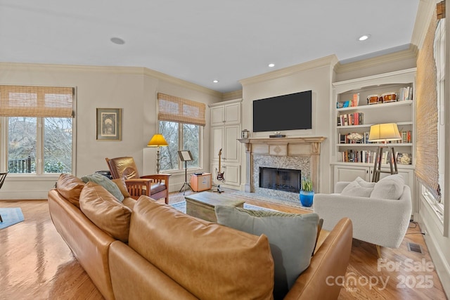 living area featuring plenty of natural light, a fireplace, light wood-style flooring, and recessed lighting