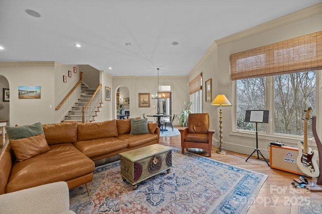 living room featuring light wood-type flooring, arched walkways, recessed lighting, and stairs