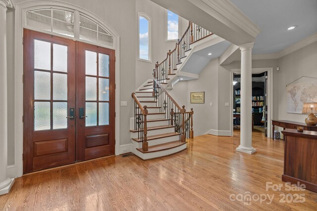 entryway with french doors, ornate columns, and wood finished floors