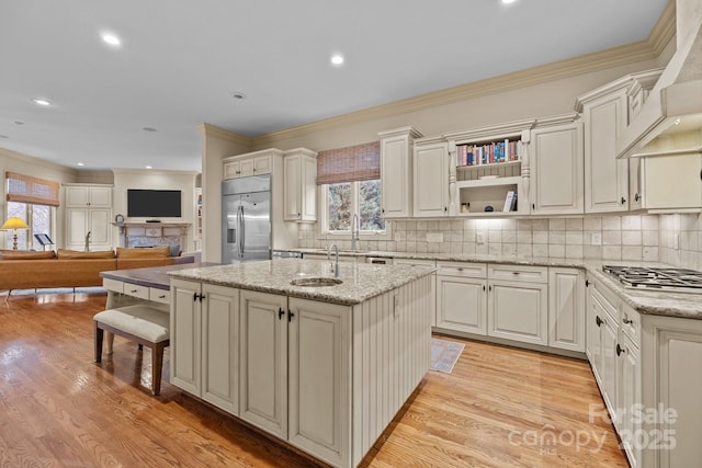 kitchen featuring appliances with stainless steel finishes, premium range hood, light wood-style floors, and tasteful backsplash