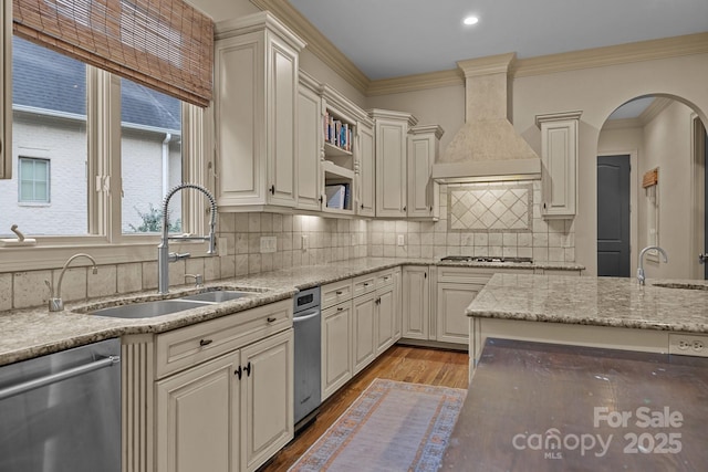 kitchen featuring premium range hood, appliances with stainless steel finishes, wood finished floors, and a sink