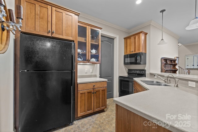 kitchen with crown molding, brown cabinetry, a sink, and black appliances