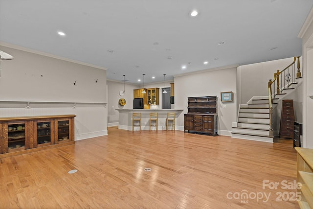 unfurnished living room featuring ornamental molding, light wood-style flooring, and recessed lighting