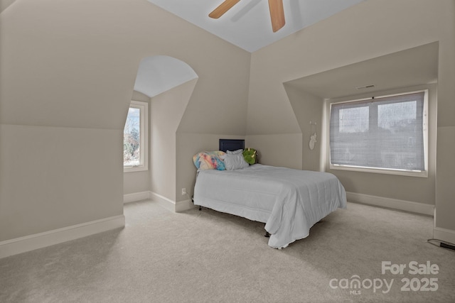 carpeted bedroom with vaulted ceiling, a ceiling fan, and baseboards