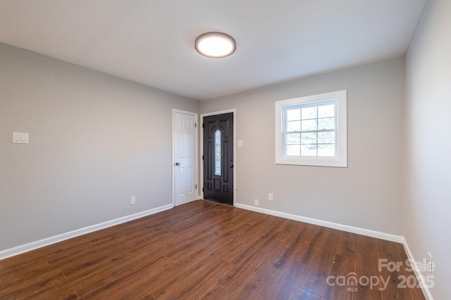 unfurnished room with dark wood-type flooring