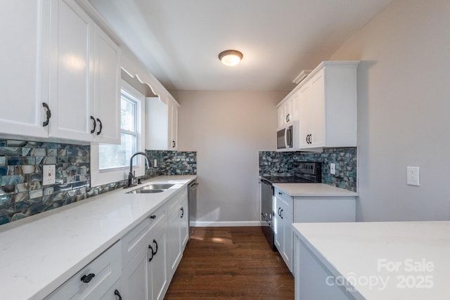 kitchen with tasteful backsplash, appliances with stainless steel finishes, sink, and white cabinetry