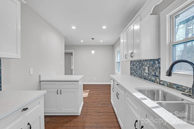 kitchen featuring white cabinetry, pendant lighting, and sink