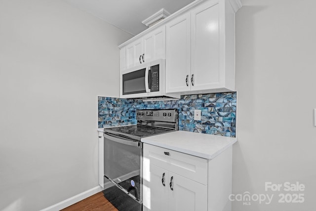 kitchen featuring electric stove, white cabinets, backsplash, and dark hardwood / wood-style floors