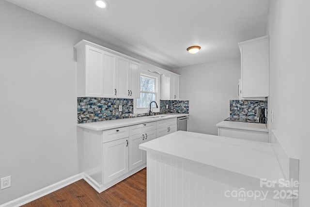 kitchen with white cabinets, sink, backsplash, dark hardwood / wood-style floors, and stainless steel dishwasher