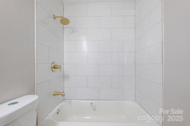 bathroom with toilet and tiled shower / bath combo