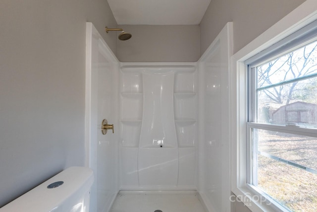 bathroom with toilet, a healthy amount of sunlight, and a shower