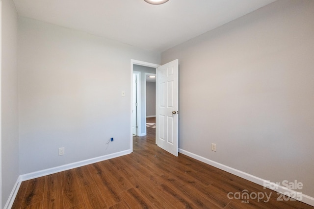 unfurnished bedroom with dark hardwood / wood-style flooring