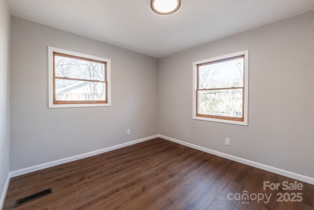 unfurnished room with dark hardwood / wood-style flooring