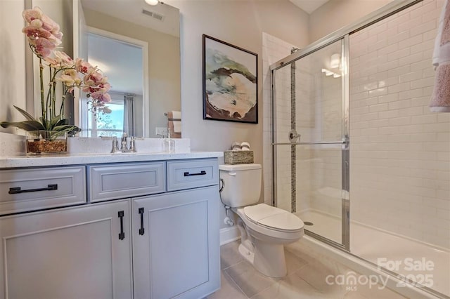 full bathroom featuring toilet, vanity, visible vents, a shower stall, and tile patterned floors