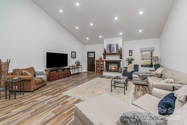 living room featuring light hardwood / wood-style flooring and high vaulted ceiling