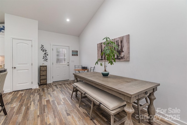 dining room with recessed lighting, light wood-type flooring, and lofted ceiling