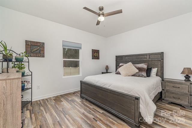 bedroom with baseboards, wood finished floors, and a ceiling fan