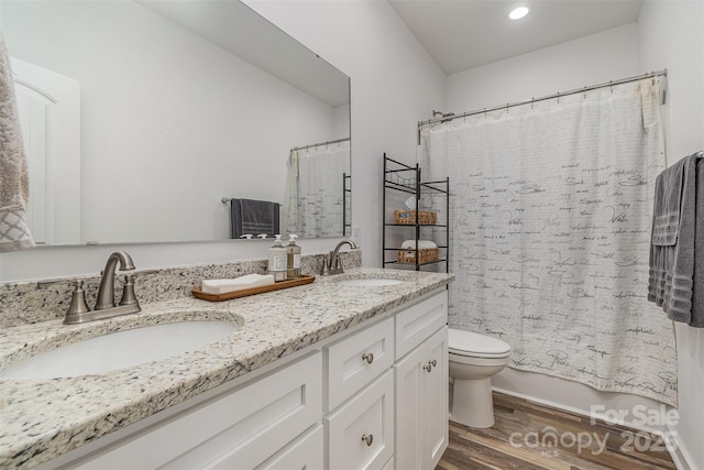 full bathroom featuring a sink, toilet, wood finished floors, and double vanity