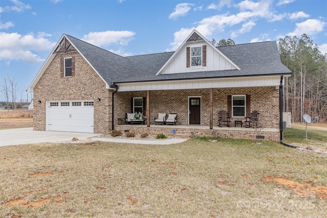 view of front of house featuring a front yard, driveway, roof with shingles, a porch, and brick siding