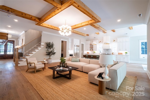 living room featuring beamed ceiling, light hardwood / wood-style flooring, and a notable chandelier