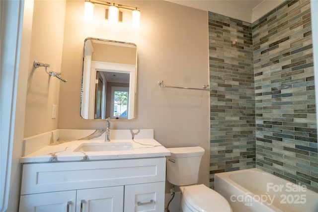 full bathroom featuring toilet, vanity, and tiled shower / bath