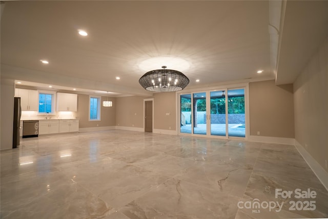 unfurnished living room with a notable chandelier and sink