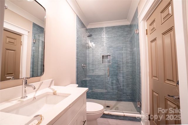 bathroom featuring toilet, vanity, a shower with door, and ornamental molding