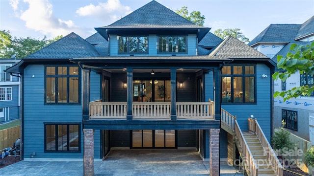 back of property with a garage and a balcony