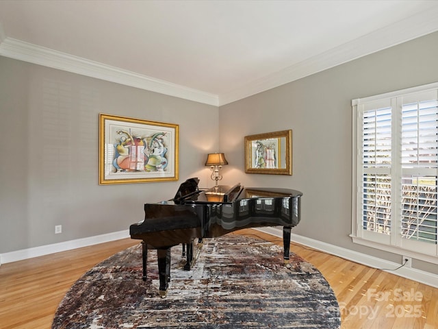 sitting room featuring baseboards, wood finished floors, and ornamental molding