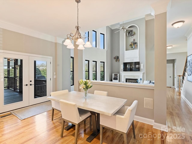 dining room with ornamental molding, visible vents, a fireplace, and light wood-type flooring