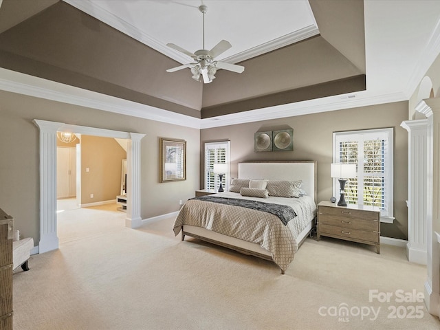 bedroom featuring ornate columns, light colored carpet, a tray ceiling, and crown molding