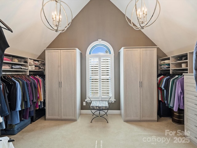 spacious closet with light carpet, an inviting chandelier, and high vaulted ceiling