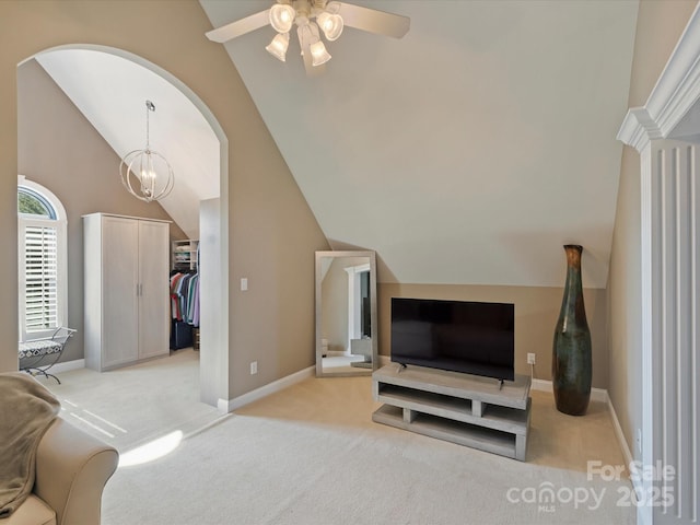 living room featuring light carpet, baseboards, arched walkways, ceiling fan with notable chandelier, and vaulted ceiling