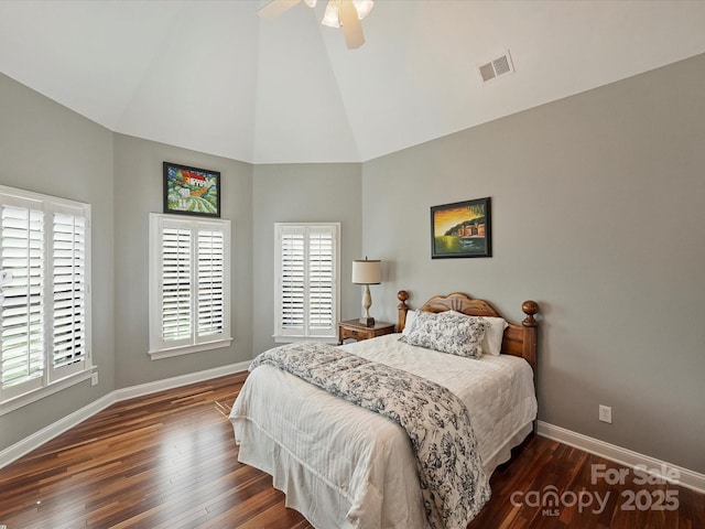 bedroom with baseboards, visible vents, dark wood-style flooring, and high vaulted ceiling