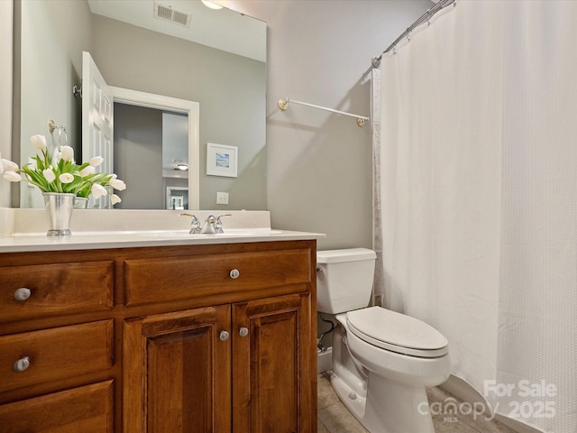 bathroom featuring toilet, visible vents, and vanity