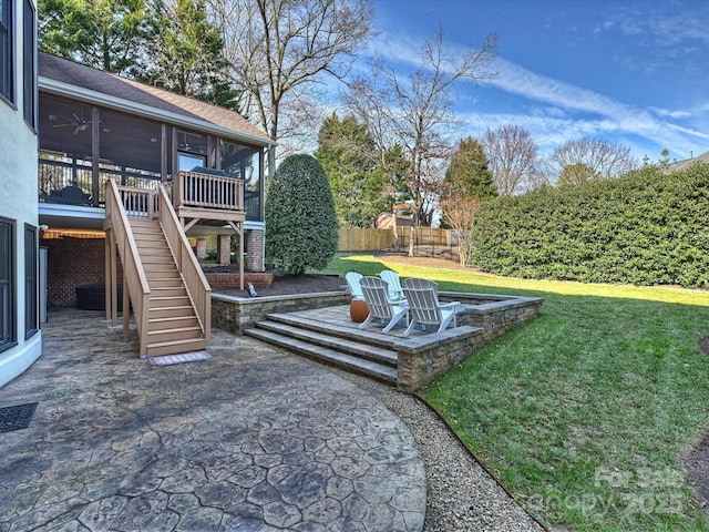 view of yard featuring a sunroom, a patio, ceiling fan, a fenced backyard, and stairs