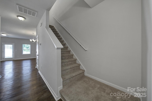 stairway featuring a chandelier