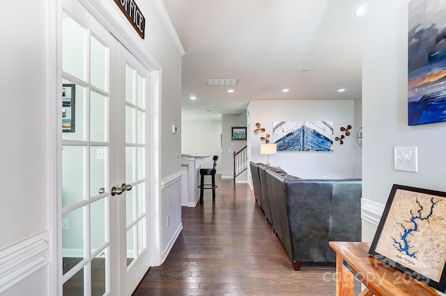 corridor featuring ornamental molding, dark hardwood / wood-style flooring, and french doors