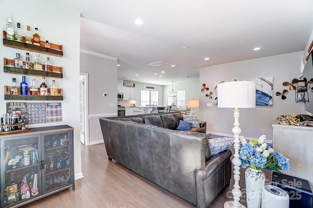 living room featuring wood-type flooring and bar area