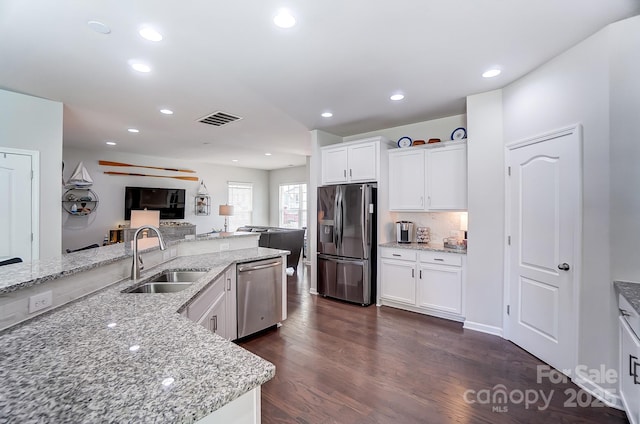 kitchen featuring sink, white cabinetry, light stone countertops, and appliances with stainless steel finishes