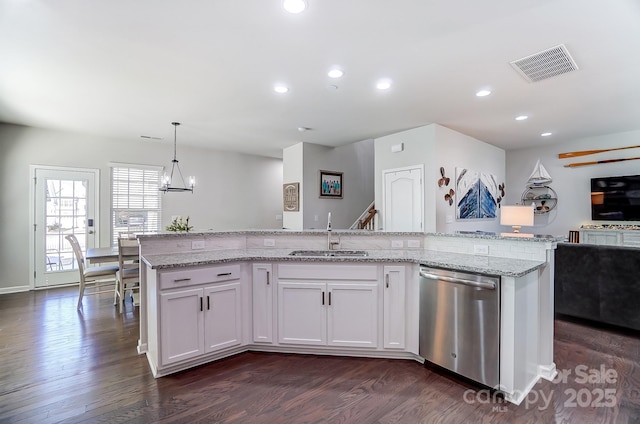 kitchen with stainless steel dishwasher, sink, decorative light fixtures, white cabinets, and an island with sink