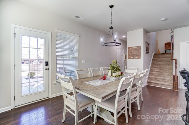 dining space with a notable chandelier and dark hardwood / wood-style flooring